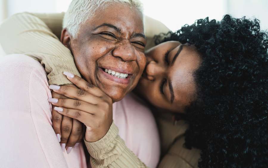 A caregiver embracing her mother